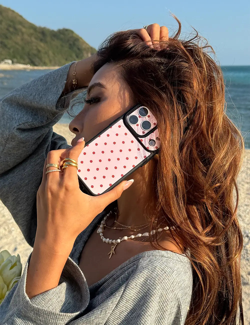Stylish individual holding our fashionable Peachy Pink Polka Dot iPhone Case on a call, showcasing its sleek design as a trendy everyday accessory.